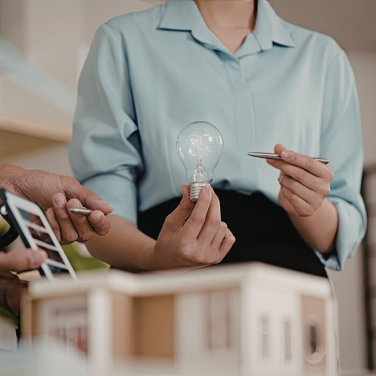 Nahaufnahme einer Frau, die eine Glühbirne in der Hand hält als Symbol für Stärke in der Krisenkommunikation